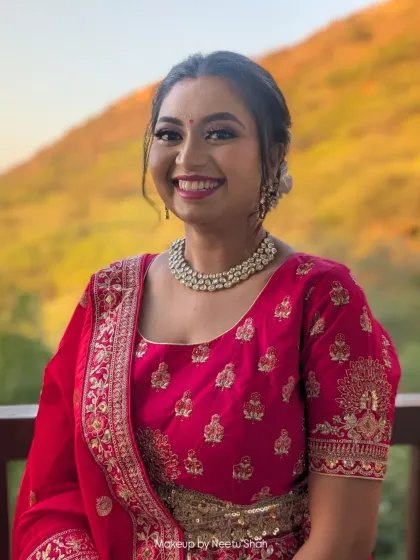 A happy client smiling for the camera. This soft glam look with a pink lehenga is perfect for a family member attending a wedding, providing a fresh and elegant appearance.