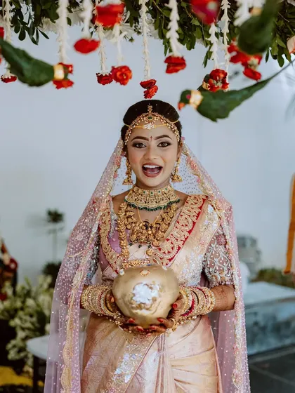 A bride's joyful expression as she participates in a wedding ritual, her happiness is truly infectious.