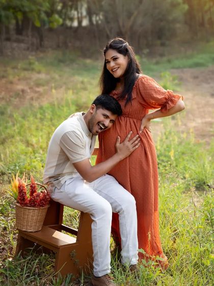 A playful and sweet moment. The father-to-be listens to the baby bump with a huge smile, creating a fun and heartwarming memory.