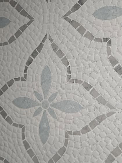 A close-up of a classic floral mosaic tile pattern. This timeless design adds a touch of handcrafted elegance to any surface.