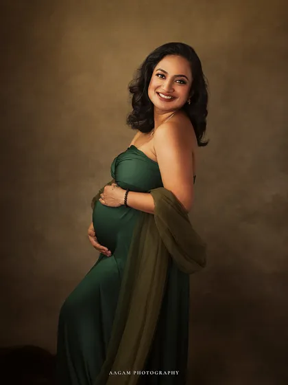 The rich green of her gown symbolizes life and vitality. Her happy, confident smile is the centerpiece of this beautiful maternity portrait.