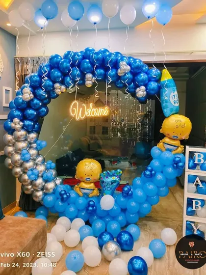 A "Welcome" decoration for a baby boy. This blue and silver balloon ring is perfect for a home celebration, complete with "BABY" blocks and themed foil balloons.