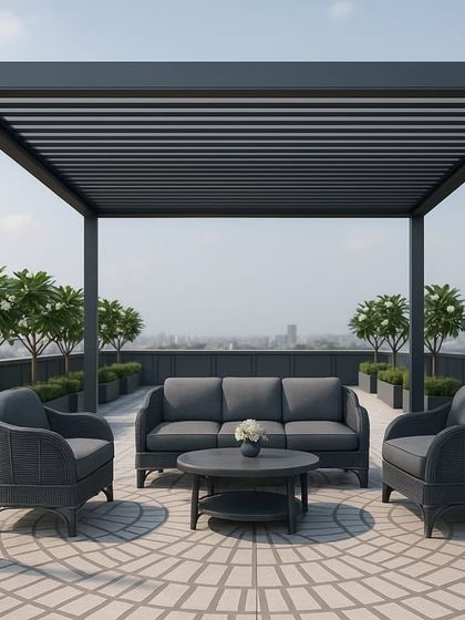 A modern rooftop lounge setup featuring a dark metal pergola and a plush grey sofa set. The circular patterned flooring adds a touch of sophistication to the space.