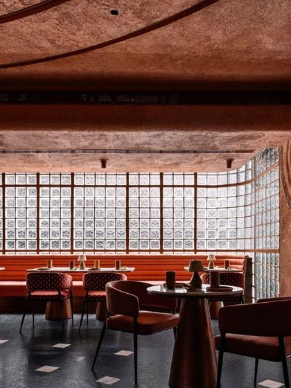 The upper dining level at Idylll, where a long banquette runs along a wall of glass blocks, creating a light and airy atmosphere that contrasts with the cavernous feel of the lower level.