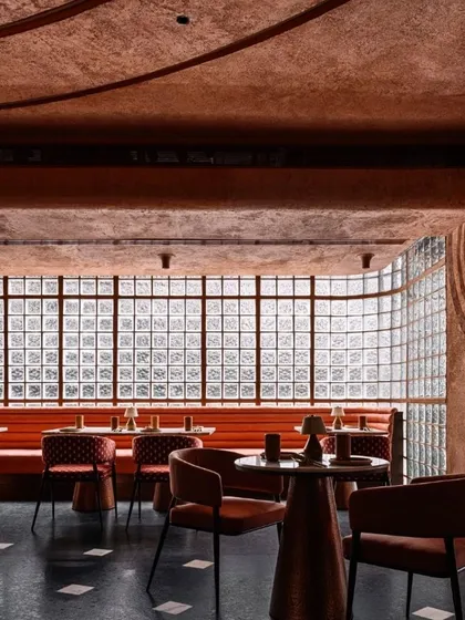 The upper dining level at Idylll, where a long banquette runs along a wall of glass blocks, creating a light and airy atmosphere that contrasts with the cavernous feel of the lower level.