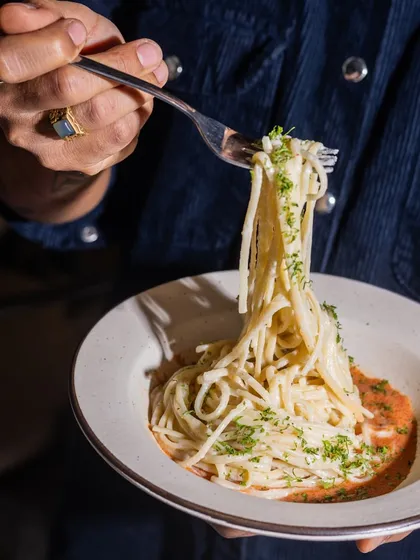 A perfect forkful of spaghetti, lifted from a bowl. This shot captures the simple joy of a good pasta dish, ready to be enjoyed.