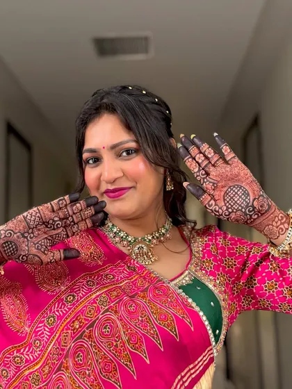 This client is glowing as she shows off the beautiful dark stain of her festive mehendi. The intricate design covers her palms completely.