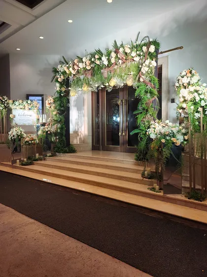 Another angle of the romantic floral entrance, showing the welcome sign and accompanying arrangements. The cohesive design creates a fully immersive experience for arriving guests.