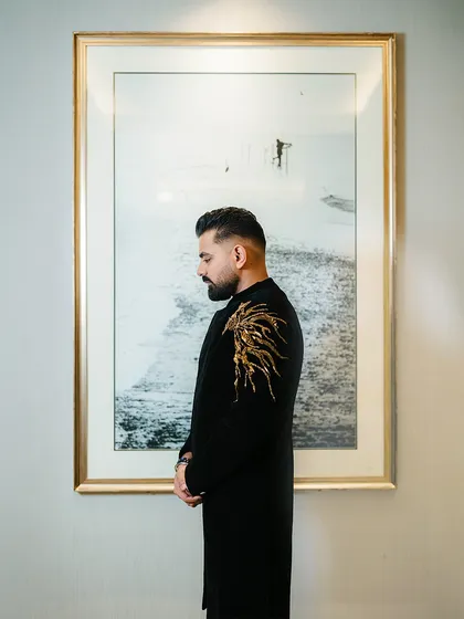 A stylish portrait of the groom before his big Sangeet performance. His embroidered black sherwani exudes elegance and confidence.