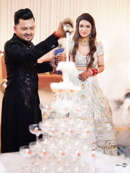 The champagne tower is a classic reception moment. I capture the couple pouring the champagne, surrounded by theatrical smoke, adding a touch of glamour and celebration.