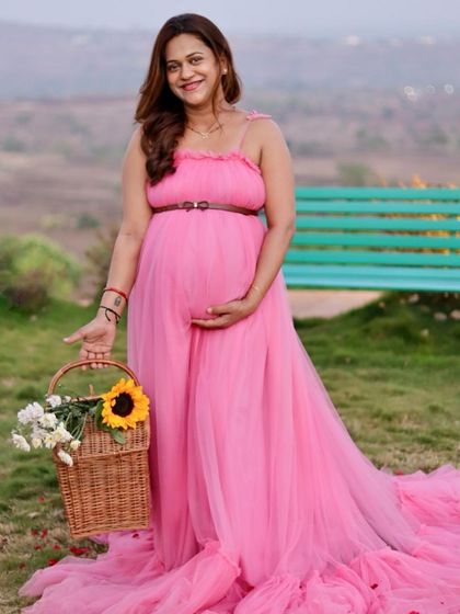 A picnic-themed maternity shoot is a lovely idea. This pink tulle gown with a simple belt is perfect for a relaxed and pretty outdoor session.