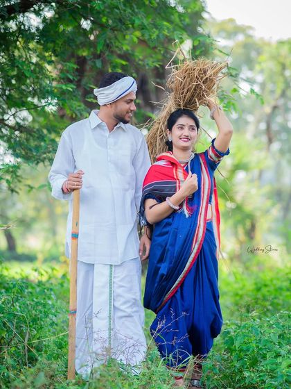 A classic pose from a Marathi farmer themed shoot. The woman carries a bundle of hay, a traditional symbol, while her partner walks alongside her, creating a timeless image of partnership.
