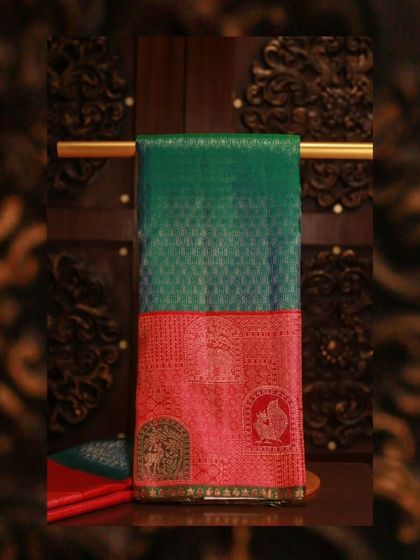 A rich green Kanjivaram with a contrasting red border featuring divine motifs, perfect for Navratri celebrations.