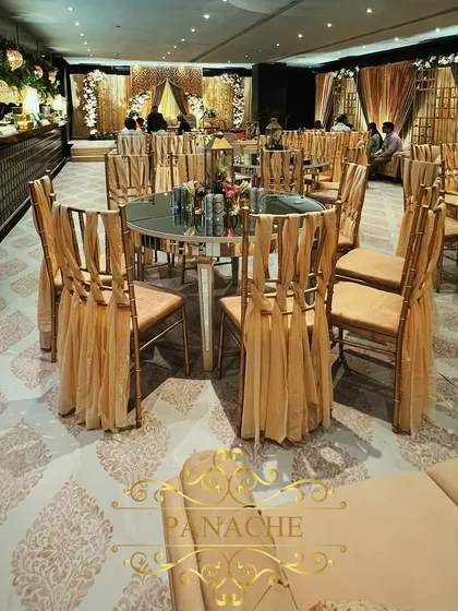 A wider view of the seating arrangement, showcasing the custom-printed carpet that complements the gold and ivory theme of the Roka ceremony.