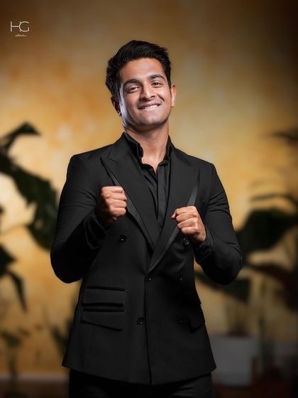 A smiling portrait of Ranveer Allahbadia in the double-breasted suit. It's a testament to feeling comfortable and powerful in what you wear.