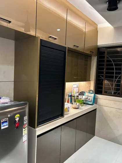 This side of the kitchen features a tall unit with a rolling shutter to neatly hide away small appliances like a mixer or toaster, keeping the countertop clutter-free.
