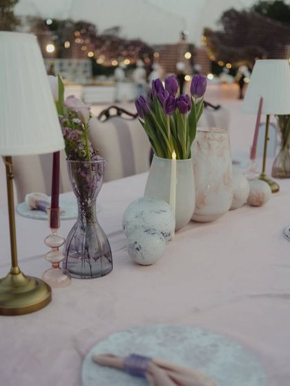 A detail shot of the table decor at the castle reception, with purple tulips and elegant lamps creating a sophisticated ambiance.