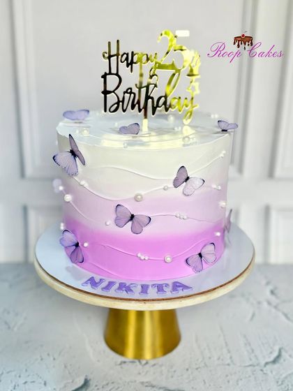 A beautiful ombre cake for a 25th birthday. The purple and white design is adorned with delicate butterflies, creating a dreamy and elegant look for Nikita's celebration.