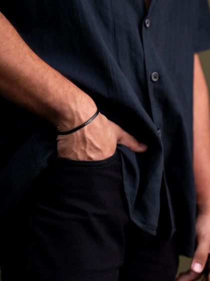 This is a subtle lifestyle shot focusing on how a men's bracelet looks when worn. The casual pose with the hand in the pocket makes the accessory feel natural and effortlessly stylish, helping customers visualize it on themselves.