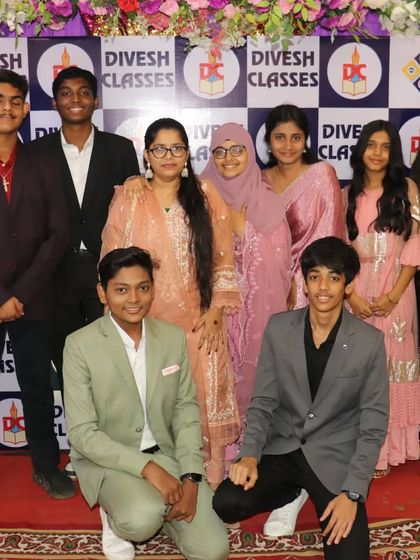 Students and teachers pose together for a group photograph, creating a lasting memory of their time at Divesh Classes.