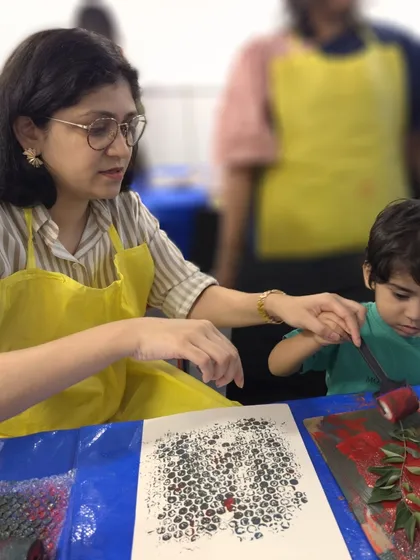 A parent and child work together during our Colourful Connects printmaking workshop. These sessions are designed to foster a stronger bond through shared creative experiences.