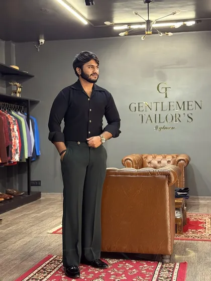 A look inside our world of bespoke tailoring. Here, our client Mr. Choudhary stands in our Delhi studio, looking dapper in a custom-fitted black shirt and flared trousers, showcasing the perfect end result of our collaborative process.