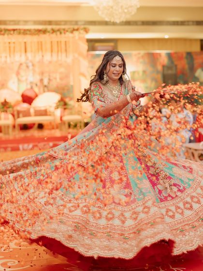 A bride twirls joyfully during her sangeet performance in Hyderabad. This picture captures the vibrant energy and color of the thematic performances I choreograph for weddings across India.
