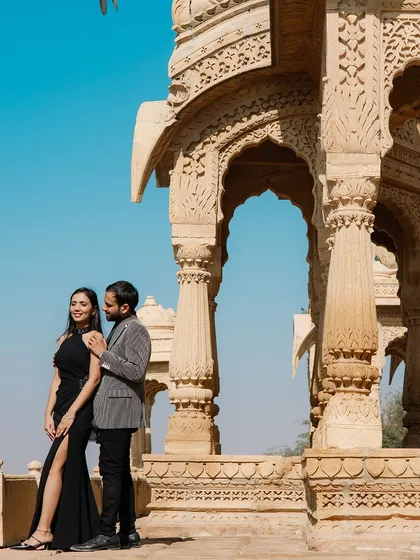 A classic portrait set against the intricate carvings of a Jaisalmer cenotaph. The combination of the couple's modern, elegant attire and the ancient, detailed architecture results in a truly timeless photograph.