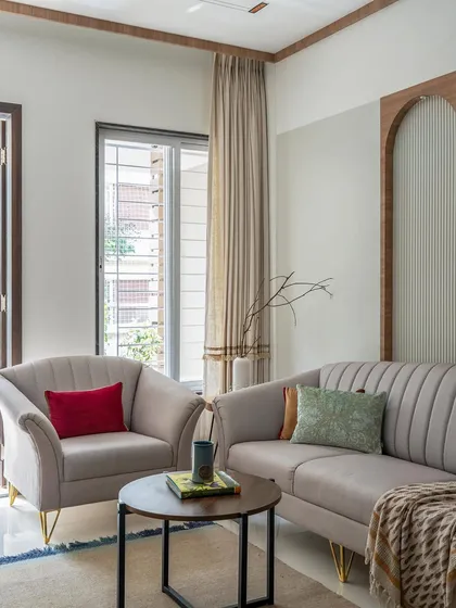 A minimalist living room with soft, neutral-toned furniture and clean lines. The design emphasizes comfort and simplicity, creating a calm and inviting space for relaxation.