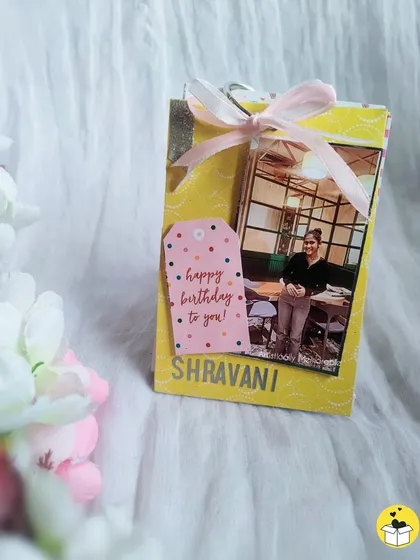 A personalized birthday mini flip book, tied with a ribbon. It's a cute and budget-friendly gift.