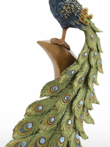 And this is the 'after'. A beautifully painted and detailed peacock sculpture, showing the final result of our clay art workshops.