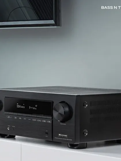 A Denon AV receiver sitting elegantly in a home entertainment setup. We choose receivers that not only deliver thrilling surround sound but also fit the aesthetic of your room.