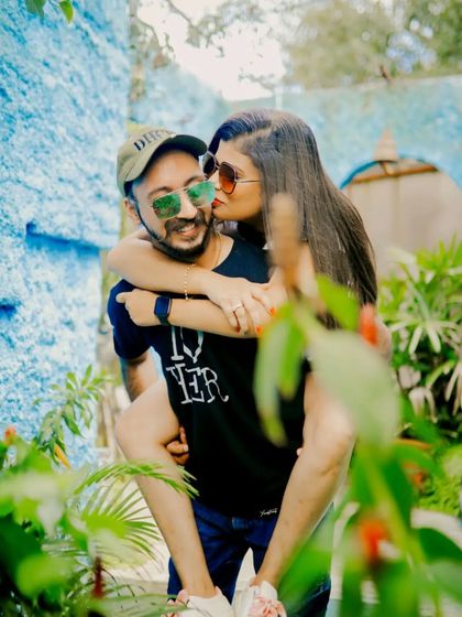 A fun, playful piggyback moment captured in a vibrant, colorful outdoor setting with lush greenery.