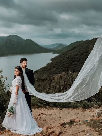 The wind catches the bride-to-be's long veil, creating a beautiful, dynamic moment. This shot combines the elegance of a classic portrait with the wildness of the natural landscape.
