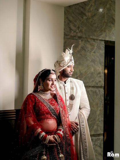 A stylish portrait of the couple, with the groom looking towards the camera while the bride looks at him, creating a dynamic and interesting composition.