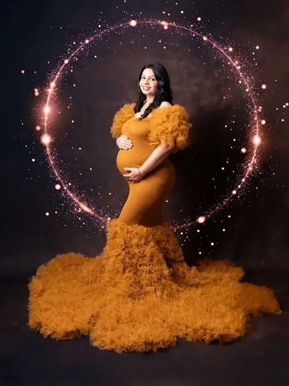 Glowing from within. This mustard yellow mermaid gown isn't just fitted; its dramatic ruffled tulle train adds incredible texture and volume for a truly glamorous maternity photo.