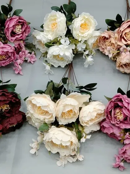 A collection of large, open artificial peony bunches in various shades of pink and white.