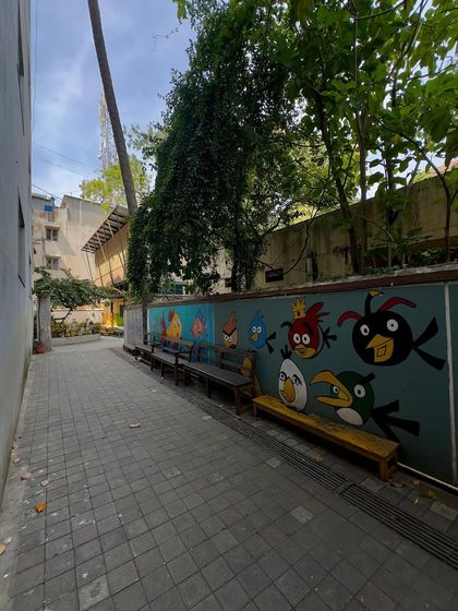 A long view of the school alley, where colorful murals and simple benches create a welcoming environment for students.