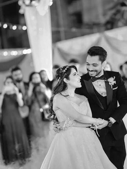 A black and white photo of the couple smiling at each other during their first dance, surrounded by fog. The moment is intimate and magical.
