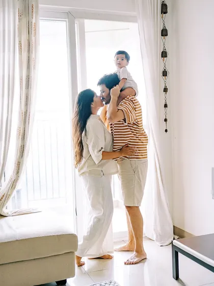 A family portrait by the window, with the baby on his dad's shoulders. A beautiful, happy memory of this fleeting stage.