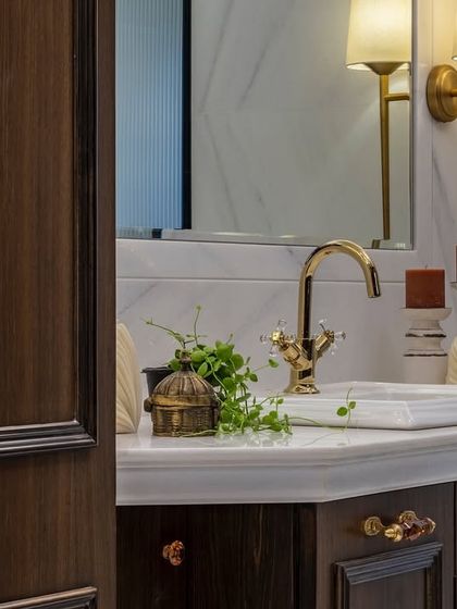 Another detail from the elegant Thane bathroom. The rich wood, classic lighting, and marble countertop combine to create a space that feels both grand and deeply personal.