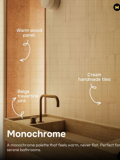 This serene bathroom uses a monochrome palette of beige and cream. The cream handmade tiles, beige travertine sink, and warm wood panel create a space that feels warm and cohesive, never flat.