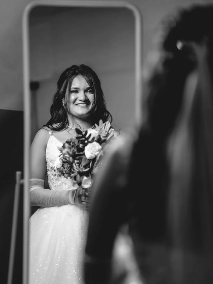 A different perspective of the bride and her reflection. This black and white photo captures her joy from another angle, adding depth to the story.