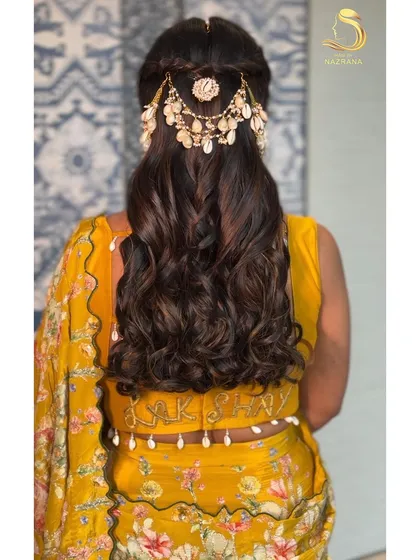 A back view of the half-up style with intricate braids and beautiful shell hair jewellery.