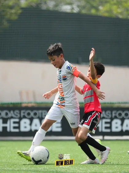 Shielding the ball under pressure. This player shows the strength and ball control skills that are essential for maintaining possession in tight spaces.