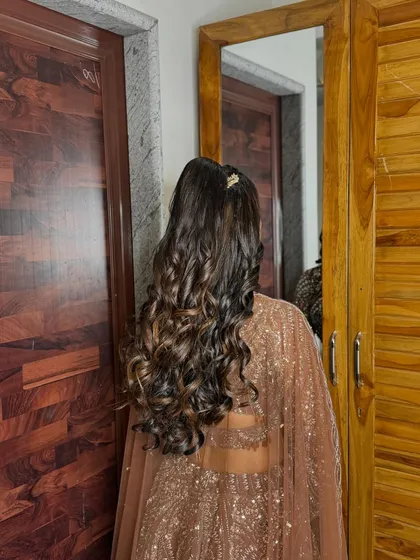 A voluminous curly ponytail, perfect for a sangeet night. It's stylish, modern, and stays in place while dancing.