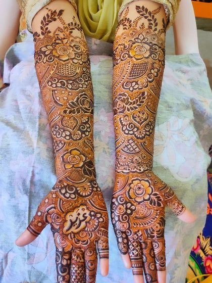 A detailed bridal design with the name 'Abdullah' written on the palm.