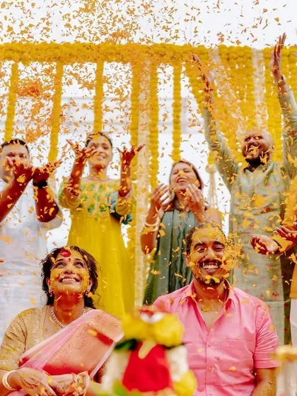A moment of pure joy, with guests showering the couple's parents in marigold petals. The backdrop of hanging garlands creates a perfect frame for this happy scene.