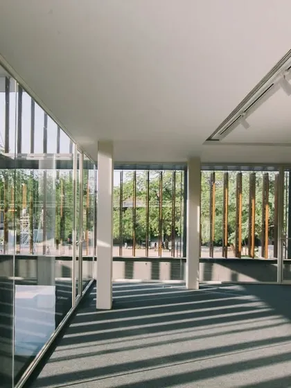 An upper-level reading area in the Lilavati Lalbhai Library offers views out to the campus through a screen of wooden louvers. This space provides a quiet zone for study while maintaining a connection to the surrounding environment.