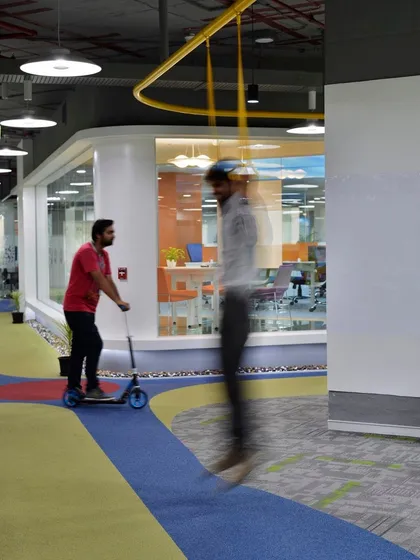 An employee using a scooter on a dedicated track within the office. We design spaces that encourage movement and fun throughout the workday.